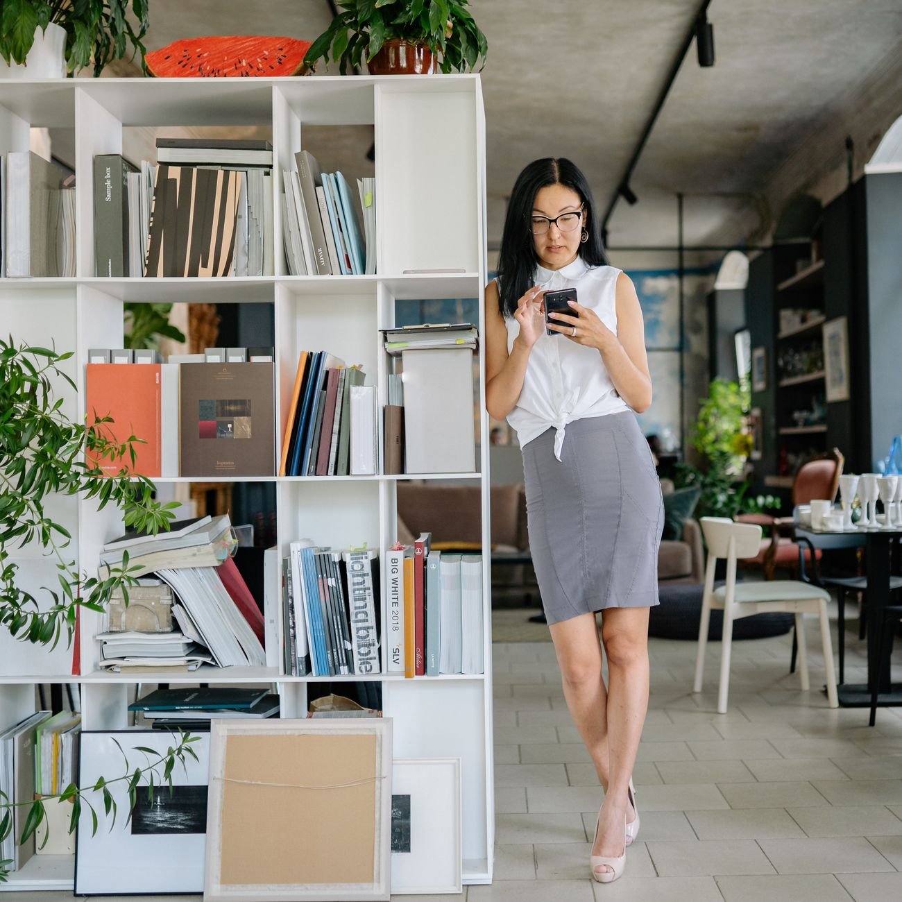 Professional woman in office, using smartphone